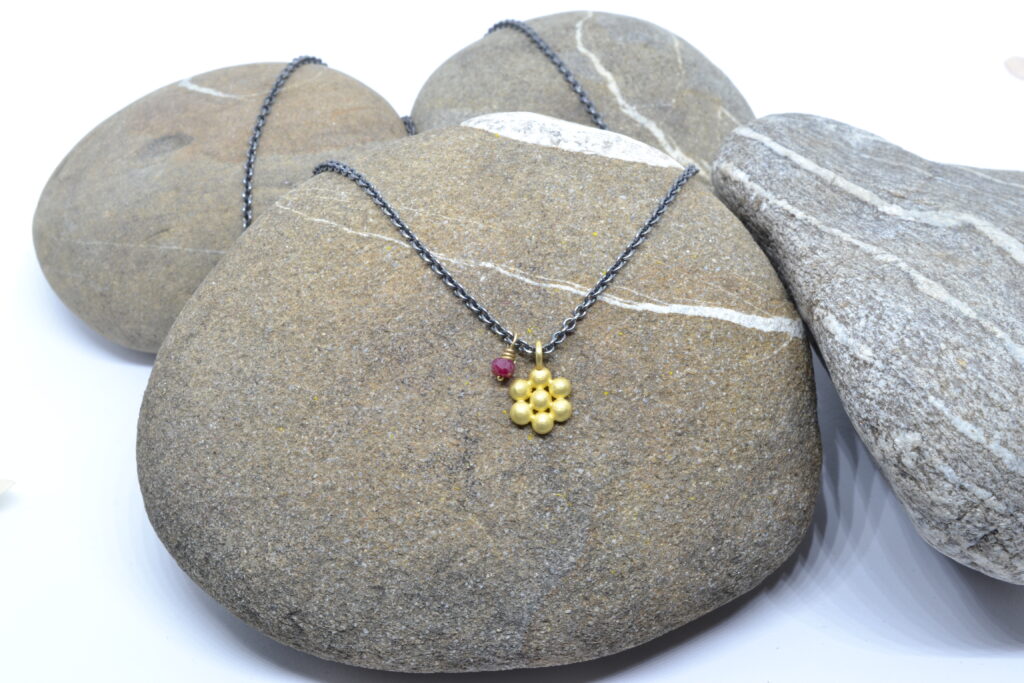 Every Day Anhänger in 750 Gelbgold mit kleinem Rubin in Golddraht gewickelt auf geschwärzter Silberkette, Design: Martina Schlichenmaier